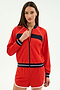 A woman poses against a plain light background wearing the SPLITS59 Carrie Woven Nylon Jacket in Lotus Red/Indigo, featuring navy and white accents and crafted from a comfortable nylon-spandex blend.