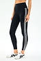 Person in SPLITS59 Ella High Waist Airweight 7/8 leggings in Black/White, featuring two white side stripes, paired with white sneakers with black accents—ideal for hot yoga or casual outings.