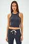 A woman with long hair, wearing a SPLITS59 Kiki Rib Crop Tank in graphite and matching jogger pants, stands against a plain background.
