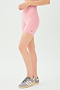 Side view of girl wearing highwaisted mid thigh pink bike shorts with grey shoes