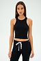 A woman models the Kiki Rib Crop Tank - Black by SPLITS59, paired with black pants featuring white drawstrings. The outfit highlights the sleek simplicity of baby rib fabric against a plain background, perfect for gym workouts.