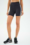 A person wearing SPLITS59's Ella High Waist Airweight Short in Graphite/White and black sneakers stands against a plain background.