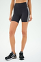 A person wearing SPLITS59's Ella High Waist Airweight Short in Graphite/White and black sneakers stands against a plain background.
