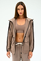 A woman with straight brown hair wears the SPLITS59 Reggie Water Repellent Jacket in Latte/Black, styled with matching taupe sportswear, against a plain white background.
