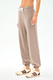 Person wearing the SPLITS59 Andie Oversized Fleece Sweatpant in Latte, featuring a white drawstring and paired with beige sneakers with maroon stripes, perfect for cool-weather workouts against a plain light background.