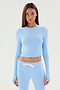 A person with long straight hair wears the SPLITS59 Louise Rib Long Sleeve Crop in Skylight, paired with matching sweatpants featuring a white drawstring, perfect for gym workouts, against a plain white background.