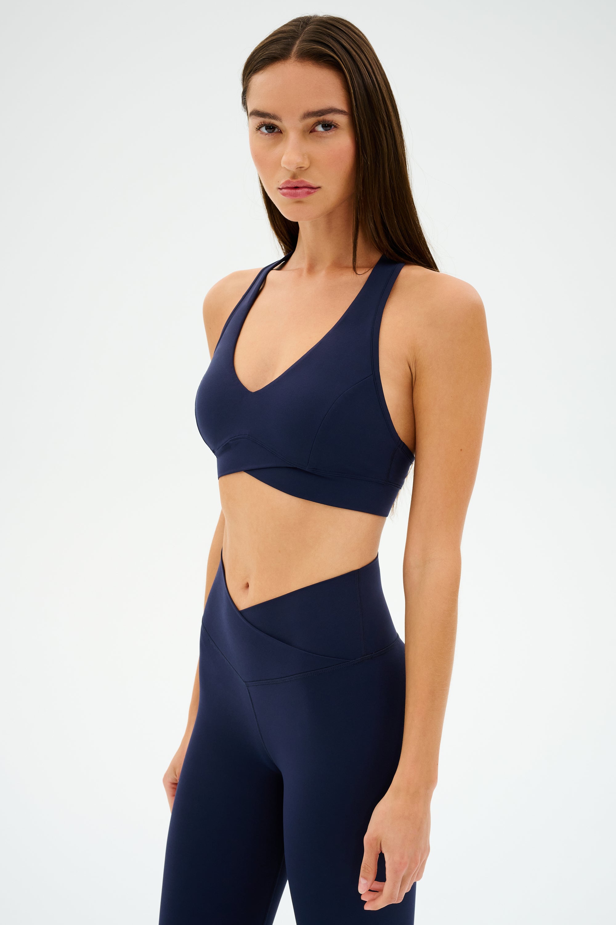 Individual in a Mia Rigor Bra - Indigo by SPLITS59, crafted with ultra-luxe Rigor fabric, poses against a plain white backdrop.