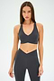 A woman wears the SPLITS59 MIA RIGOR BRA and matching high-waisted leggings, crafted from soft nylon spandex, standing against a plain light background.