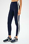 A person wears SPLITS59 Clare High Waist Rigor 7/8 leggings in Dark Cherry/Creme, paired with blue New Balance sneakers, standing against a plain white background.