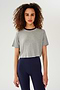 Front view of girl wearing light grey cropped short sleeve t-shirt with thin dark blue neck hem and dark blue leggings
