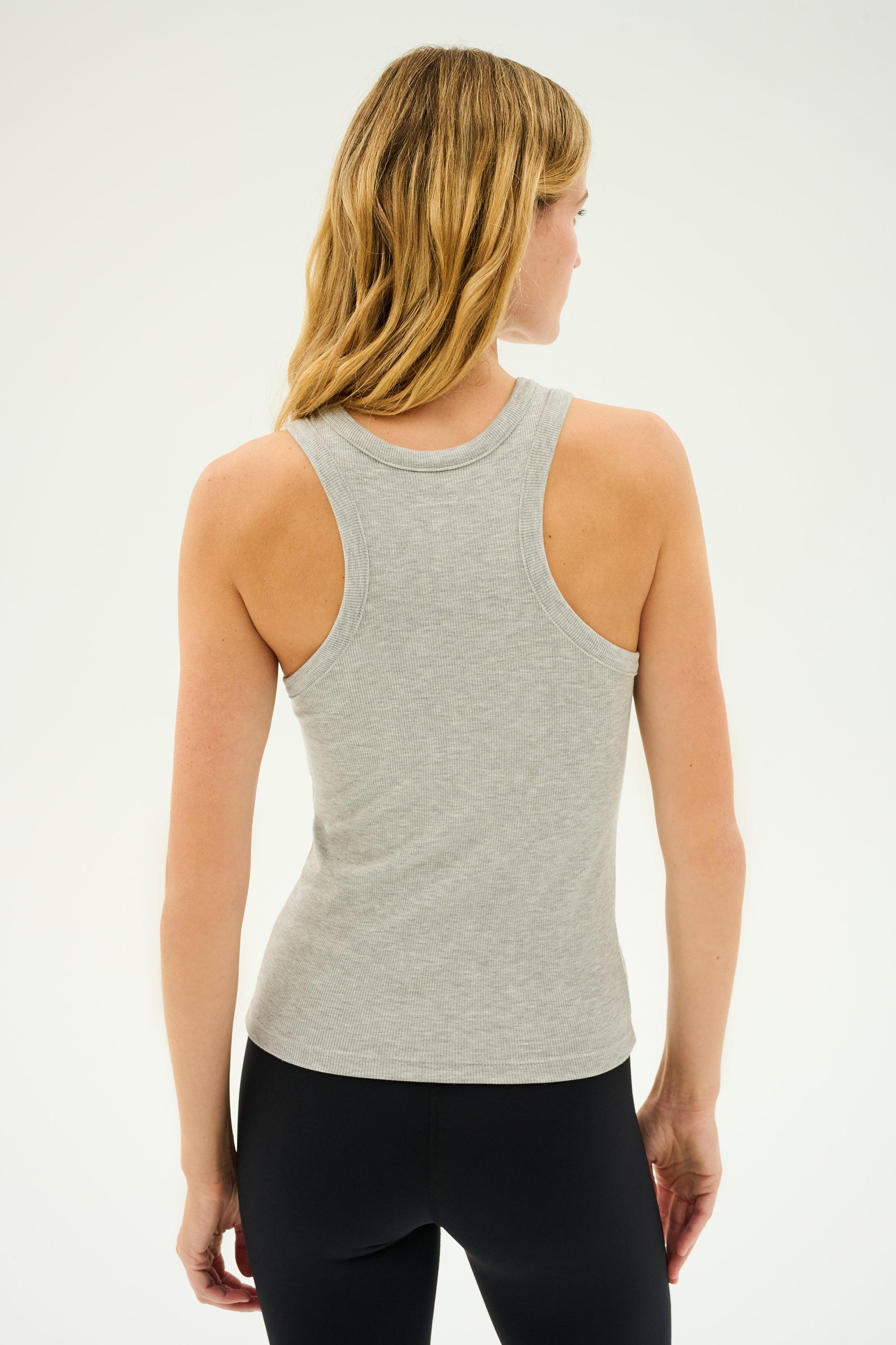 Person wearing the SPLITS59 Kiki Rib Tank Full Length in Heather Grey and black pants, standing with their back towards the camera, as if ready for some intense gym workouts.