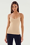 A person with long hair wearing the SPLITS59 Loren Seamless Waist Length Tank in Nude and black pants stands against a plain background.