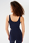 Back view of woman with curly dark brown hair wearing a dark blue bra crop tank with dark blue leggings