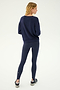 A person stands facing away on a white background, wearing the SPLITS59 Sonja Fleece Sweatshirt in Indigo, paired with matching navy leggings and black sneakers.