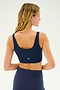 A woman with long, blonde hair is shown from the back wearing the SPLITS59 Sprint Rigor Bra in Indigo and matching leggings, perfect for multi-sport performance, against a plain background.