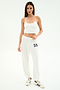 Woman standing against a white background wears a white crop top, SPLITS59 Andie Oversized Fleece Varsity 59 Sweatpant in White/59, and white Adidas sneakers—ideal for cool weather workouts. MADE IN LOS ANGELES.