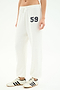 A person in SPLITS59 Andie Oversized Fleece Varsity 59 Sweatpant—white with bold "59"—paired with white sneakers with black stripes, perfect for cool weather workouts. Made in Los Angeles.