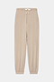 The SPLITS59 Andie Oversized Fleece Sweatpant in Latte features an elasticated waistband and cuffs, perfect for warm-ups or cool weather workouts, shown laid flat on a white background.