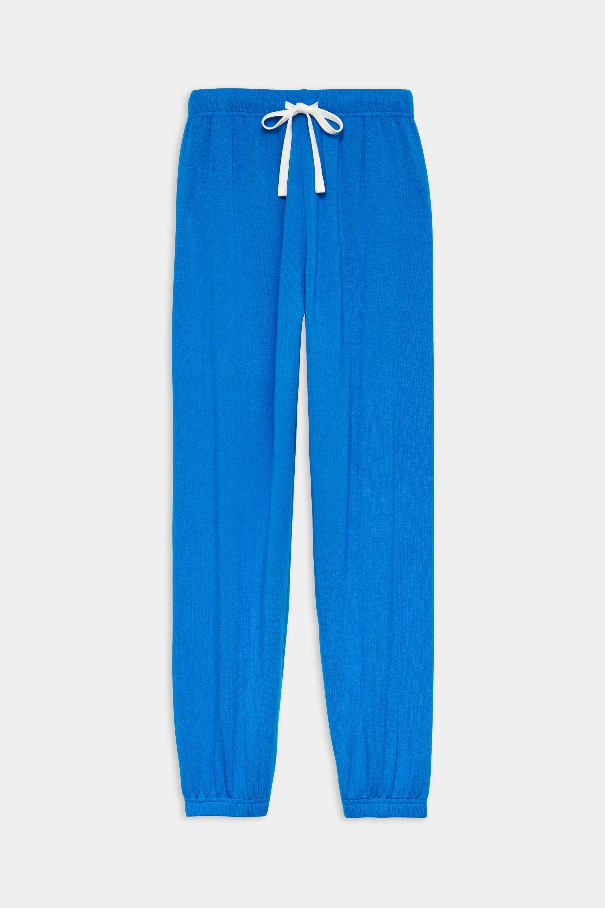 The SPLITS59 Andie Oversized Fleece Sweatpant in Classic Blue features a soft modal-spandex blend, elastic waistband with a white drawstring, and elastic cuffs, shown laid flat on a white background.