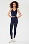 A person stands against a plain background wearing the SPLITS59 Sprint Rigor Bralette in Indigo with matching high-waisted leggings and white sneakers.