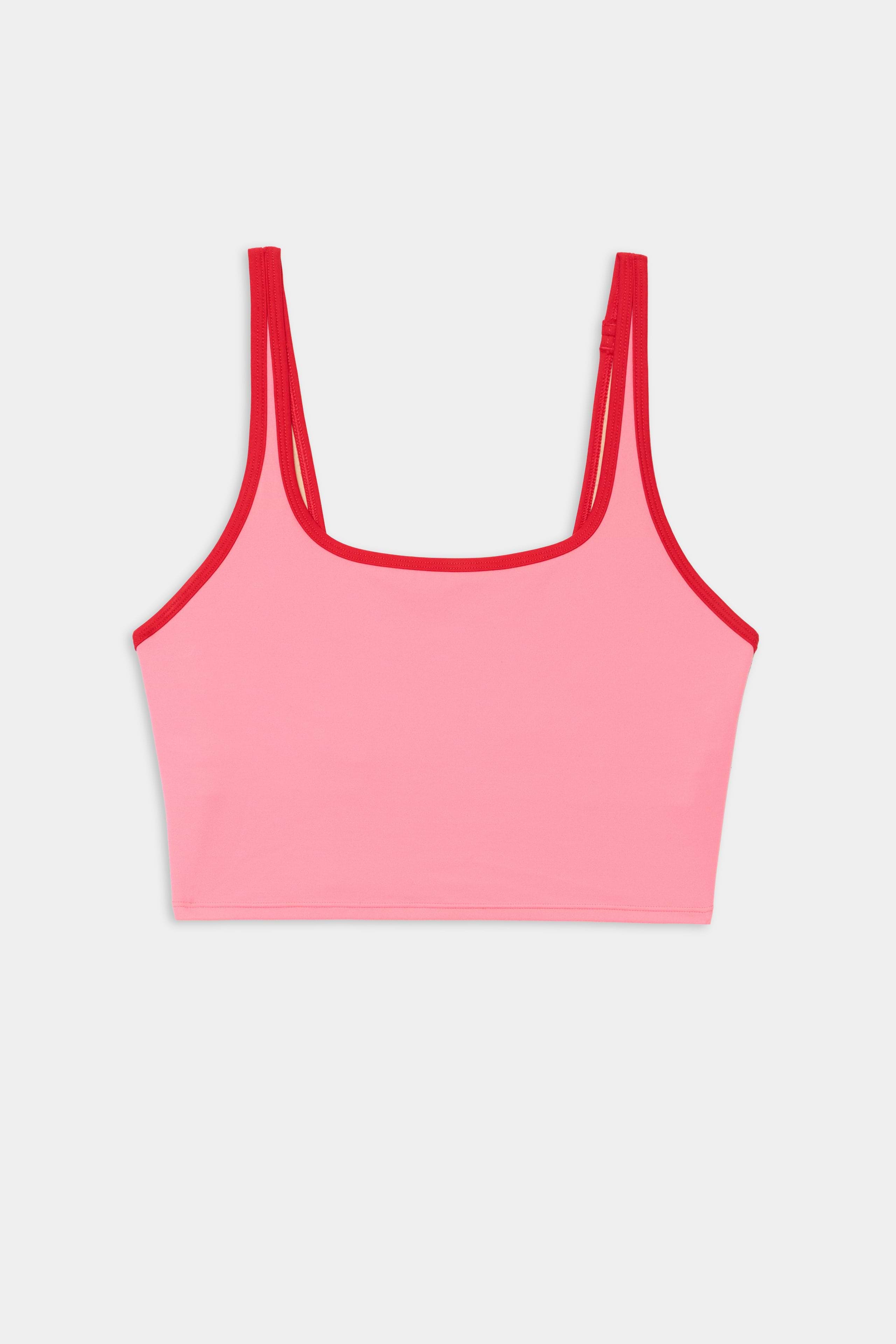 The SPLITS59 Cait Rigor Bralette in Strawberry/Pirate Red features pink nylon-spandex fabric with red trim and spaghetti straps, showcased against a plain white background.