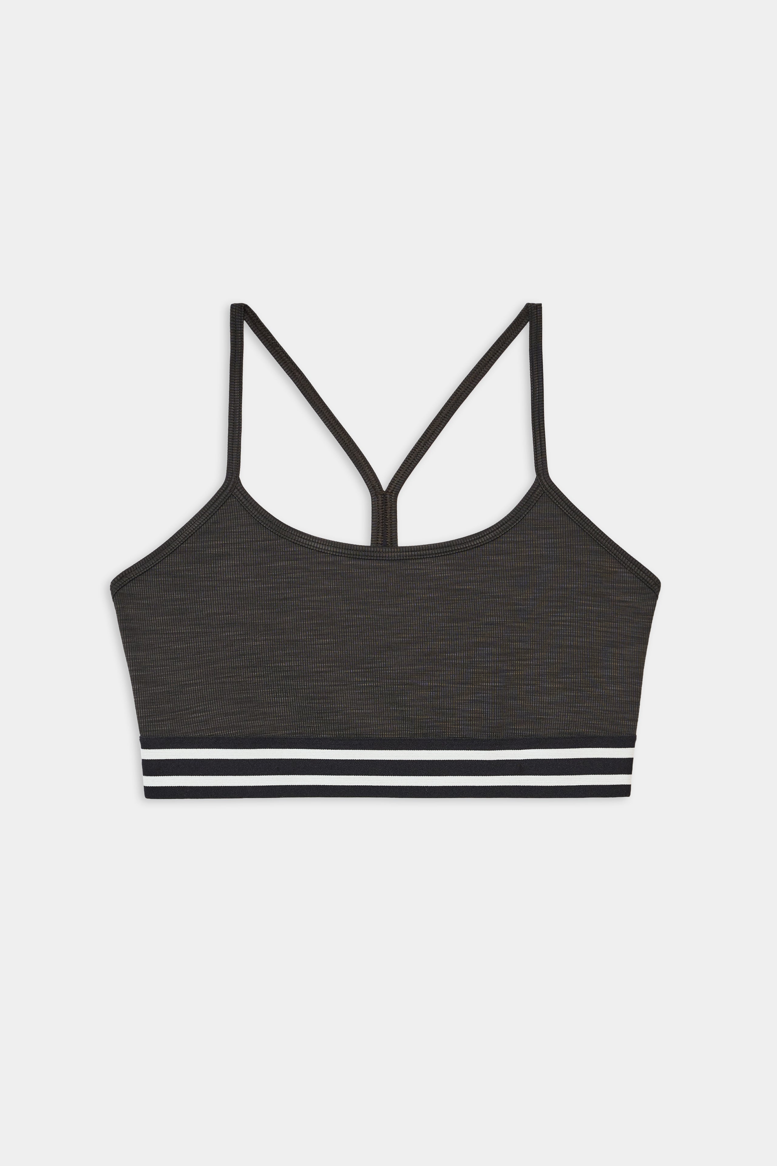 The SPLITS59 Cali Active Rib Bra in Heather Graphite is a supportive sports bra with thin straps, a racerback design, and a white-and-black striped elastic band at the bottom.