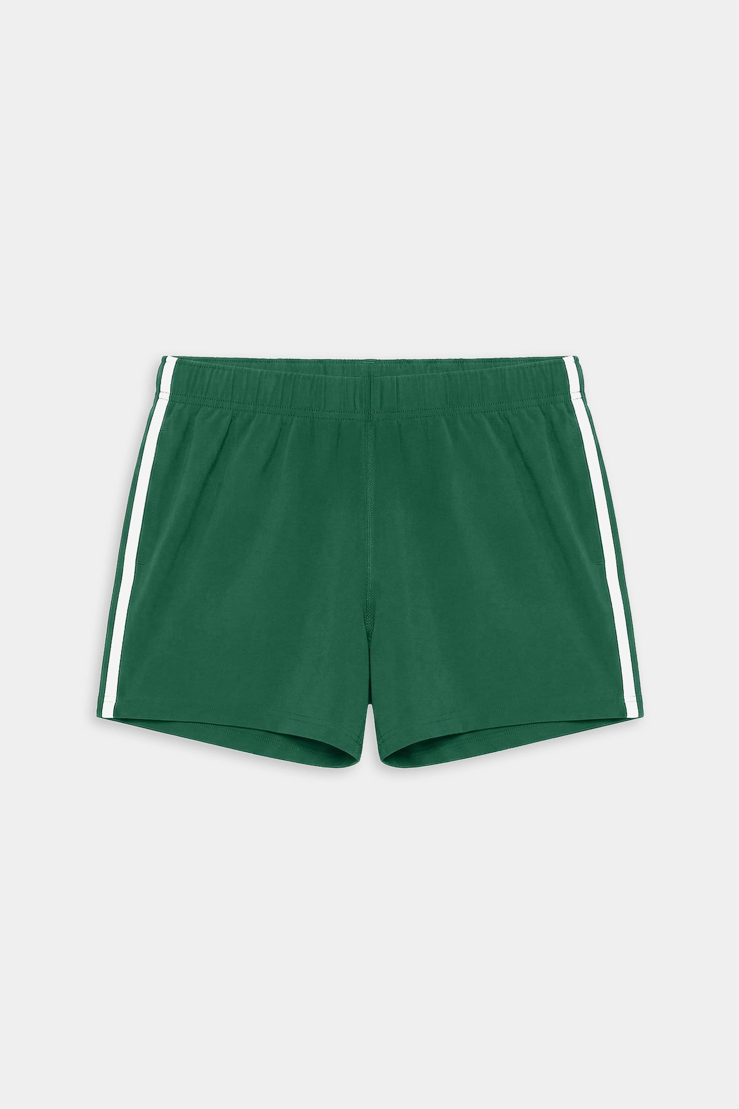 The SPLITS59 Ella Airweight Track Short in Arugula/White features lightweight fabric, white side stripes, and an elastic waistband—ideal for hot yoga or casual workouts. Laid flat on a plain background.