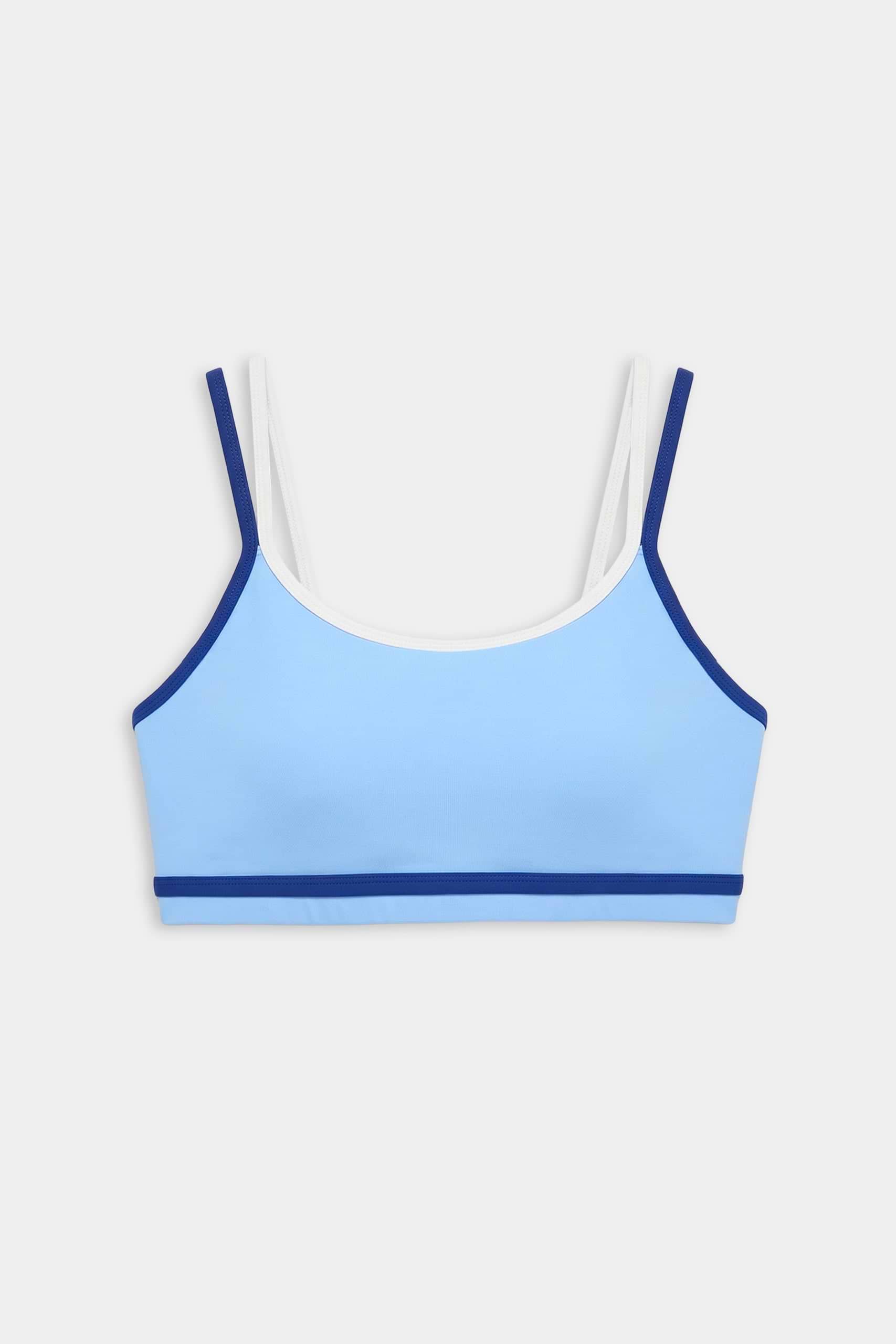 The SPLITS59 Eva Rigor Double Strap Bra in Skylight/Cobalt features light blue fabric with dark blue trim and white double straps, perfect for the gym, displayed against a plain white background.
