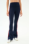 A person wears SPLITS59 Raquel High Waist Flared Legging in Indigo/Lotus Red with white sneakers, shown from waist to feet against a plain background. These leggings feature comfortable 4-way stretch for easy movement.
