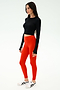 A woman wears the SPLITS59 Louise Rib Long Sleeve Crop in black, paired with vibrant red leggings and white sneakers, set against a plain white background.