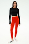 A person stands facing forward against a plain white background, wearing the SPLITS59 Louise Rib Long Sleeve Crop in black, bright red leggings, and white sneakers.