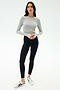 A woman stands against a white background wearing the SPLITS59 Louise Rib Long Sleeve Crop in Heather Grey, black leggings, and white sneakers with black accents.