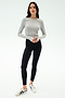 A woman stands against a white background wearing the SPLITS59 Louise Rib Long Sleeve Crop in Heather Grey, black leggings, and white sneakers with black accents.