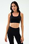 A woman models the SPLITS59 Sprint Rigor Bra in black, standing against a simple light background—ideal for gym workouts or versatile multi-sport performance.