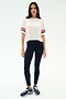 A woman wears the SPLITS59 Ava Jersey Tee in White/Indigo, featuring a relaxed fit and sporty sleeve stripes, paired with blue leggings—perfect for gym workouts.