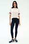 A woman wears the SPLITS59 Ava Jersey Tee in White/Indigo, featuring a relaxed fit and sporty sleeve stripes, paired with blue leggings—perfect for gym workouts.