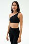 A woman models the SPLITS59 Josie Airweight One Shoulder Bra in Black/White with matching leggings, ideal for hot yoga, against a simple light backdrop.