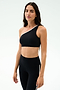 A woman models the SPLITS59 Josie Airweight One Shoulder Bra in Black/White with matching leggings, ideal for hot yoga, against a simple light backdrop.