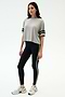 A woman stands against a plain background wearing the SPLITS59 Ava Jersey Tee in Heather Grey/Black, paired with black leggings with a white side stripe and white sneakers, ready for her gym workout.