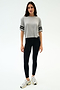 A woman poses against a white backdrop in the SPLITS59 Ava Jersey Tee - Heather Grey/Black, styled with black leggings and white athletic shoes—ideal for workouts or running.