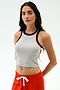 A woman with long dark hair models the SPLITS59 Kiki Rib Crop Tank in Heather Grey/Black, paired with red drawstring pants, standing against a plain light background.