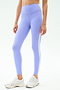A person wears SPLITS59 Clare High Waist Rigor 7/8 leggings in Purple Haze/White with white athletic shoes, ideal for gym workouts, standing against a plain background.