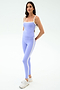 A woman poses against a plain background wearing SPLITS59 Clare High Waist Rigor 7/8 leggings in Purple Haze/White with white sneakers, looking at the camera with a neutral expression—ideal for gym workouts.