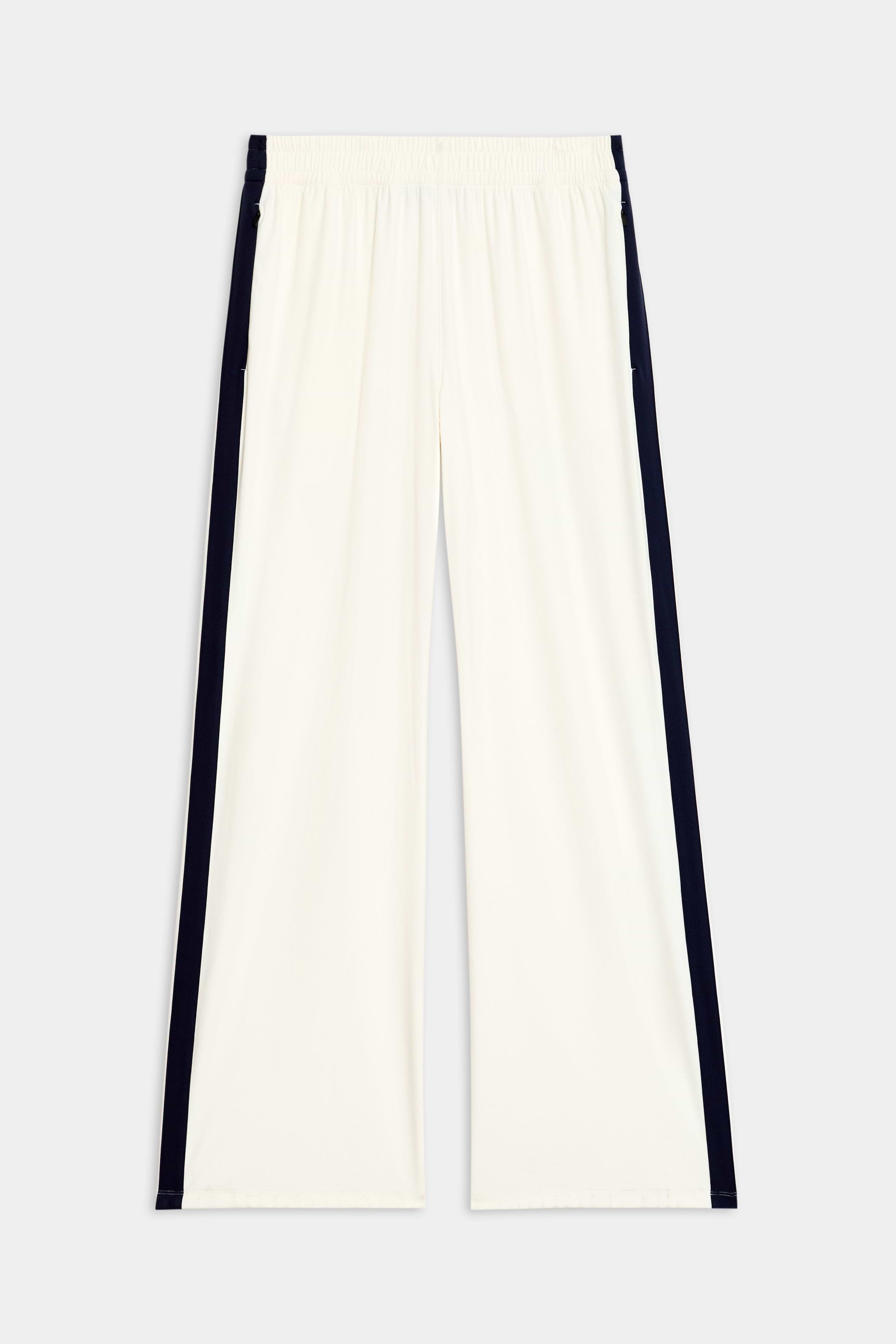 The Maxie Rigor Track Pant in white and indigo from SPLITS59, made from rigor fabric with an elastic waistband, is shown on a plain background.