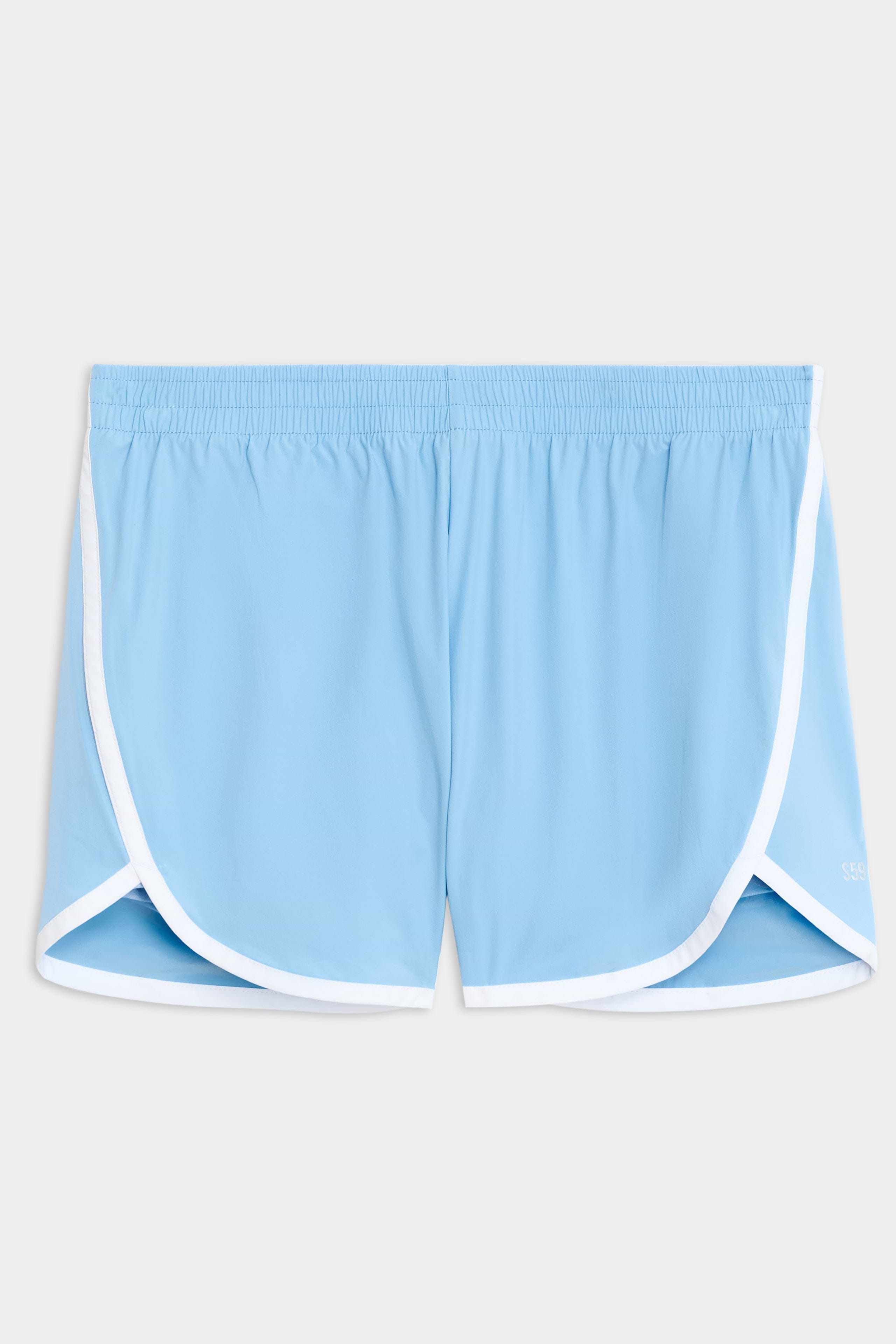 The SPLITS59 Megan Woven Nylon Run Shorts feature a light blue color, elastic waistband, and white trim on the edges, set against a plain background.