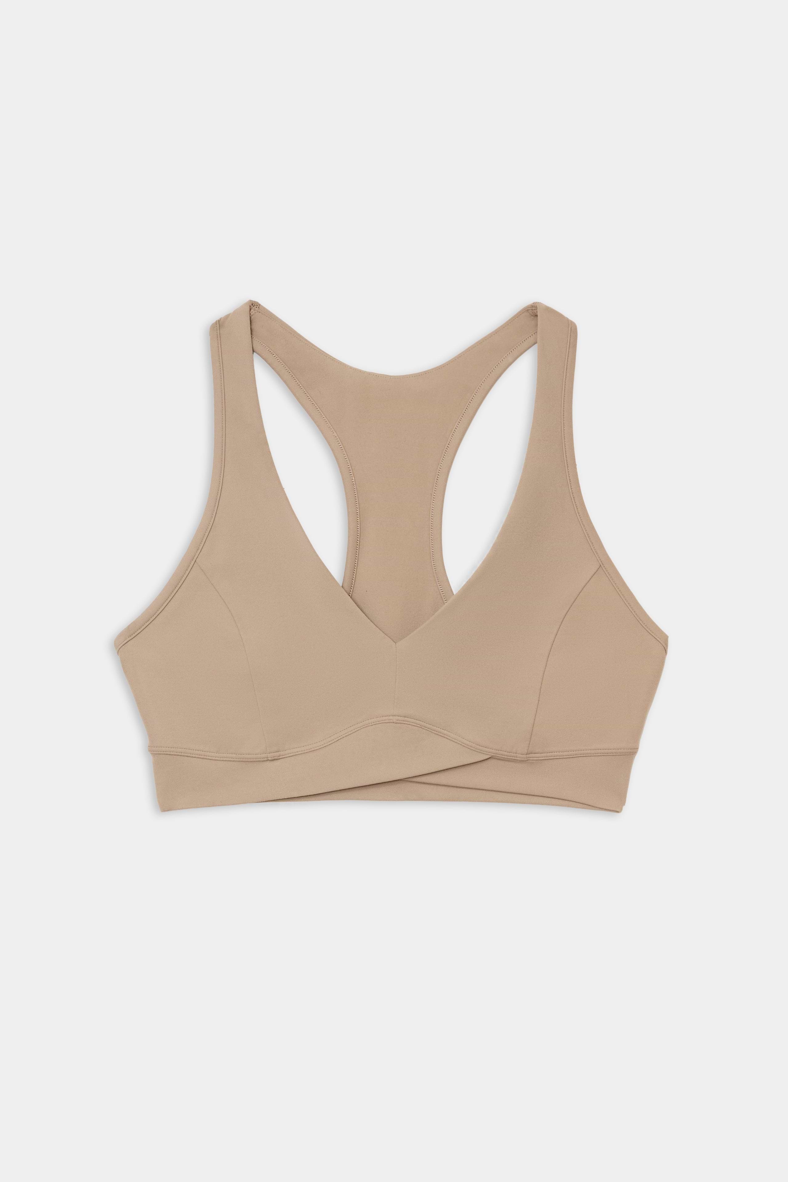 The SPLITS59 Mia Rigor Bra in Latte, a beige racerback sports bra crafted from a soft nylon-spandex blend, is laid flat on a white background.