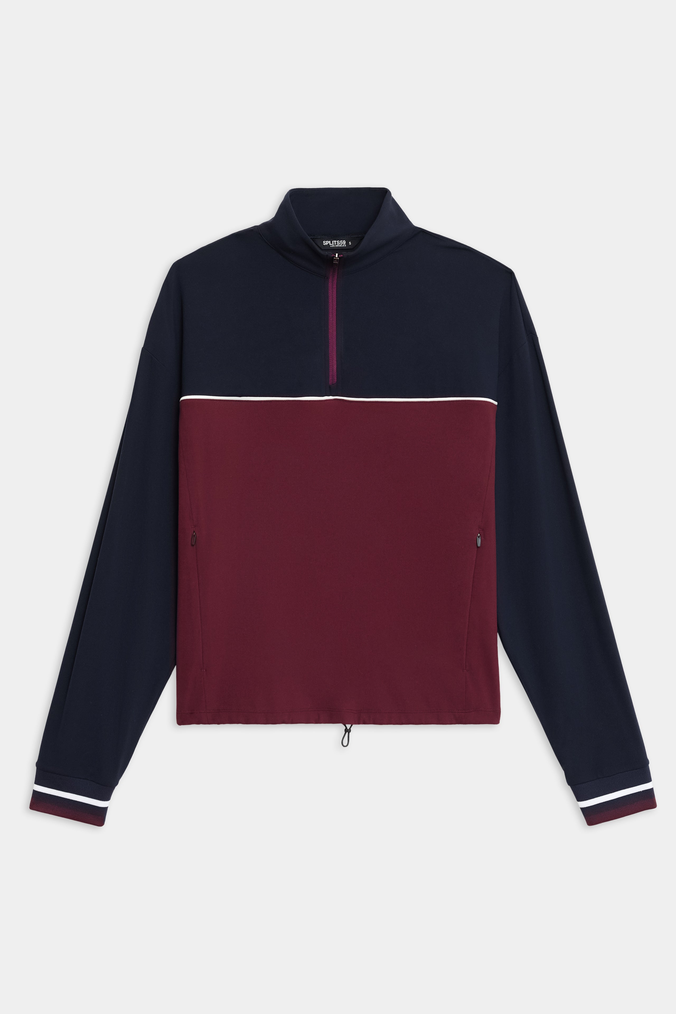 The SPLITS59 Millie Airweight Half Zip is a long-sleeve pullover featuring a navy top, burgundy bottom, white stripe, quarter zip, and zippered side pockets, shown on a white background.