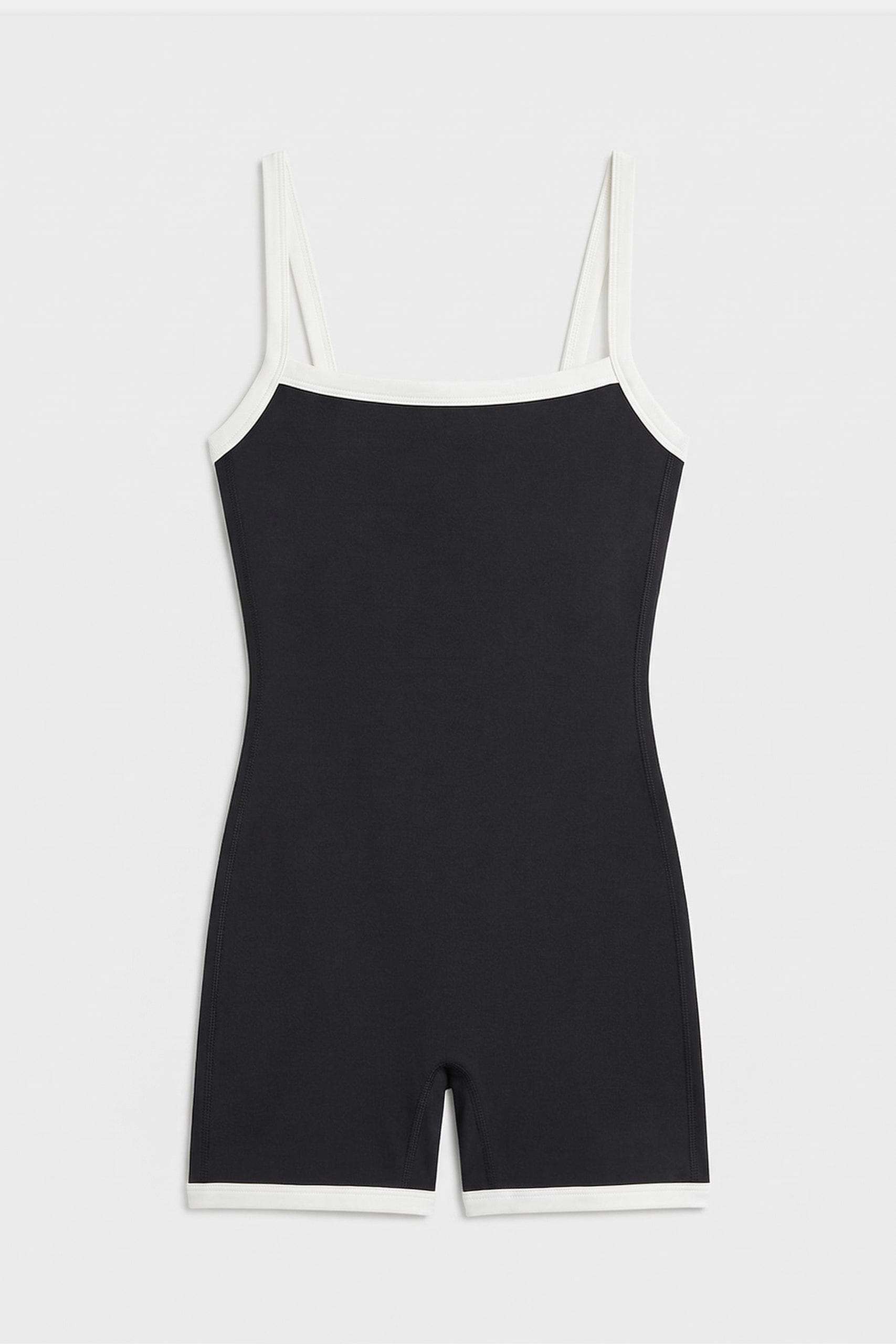 The SPLITS59 Monah Rigor Jumpsuit - Black/White is a sleeveless one-piece with white trim and a supportive fit, shown flat on a white background.