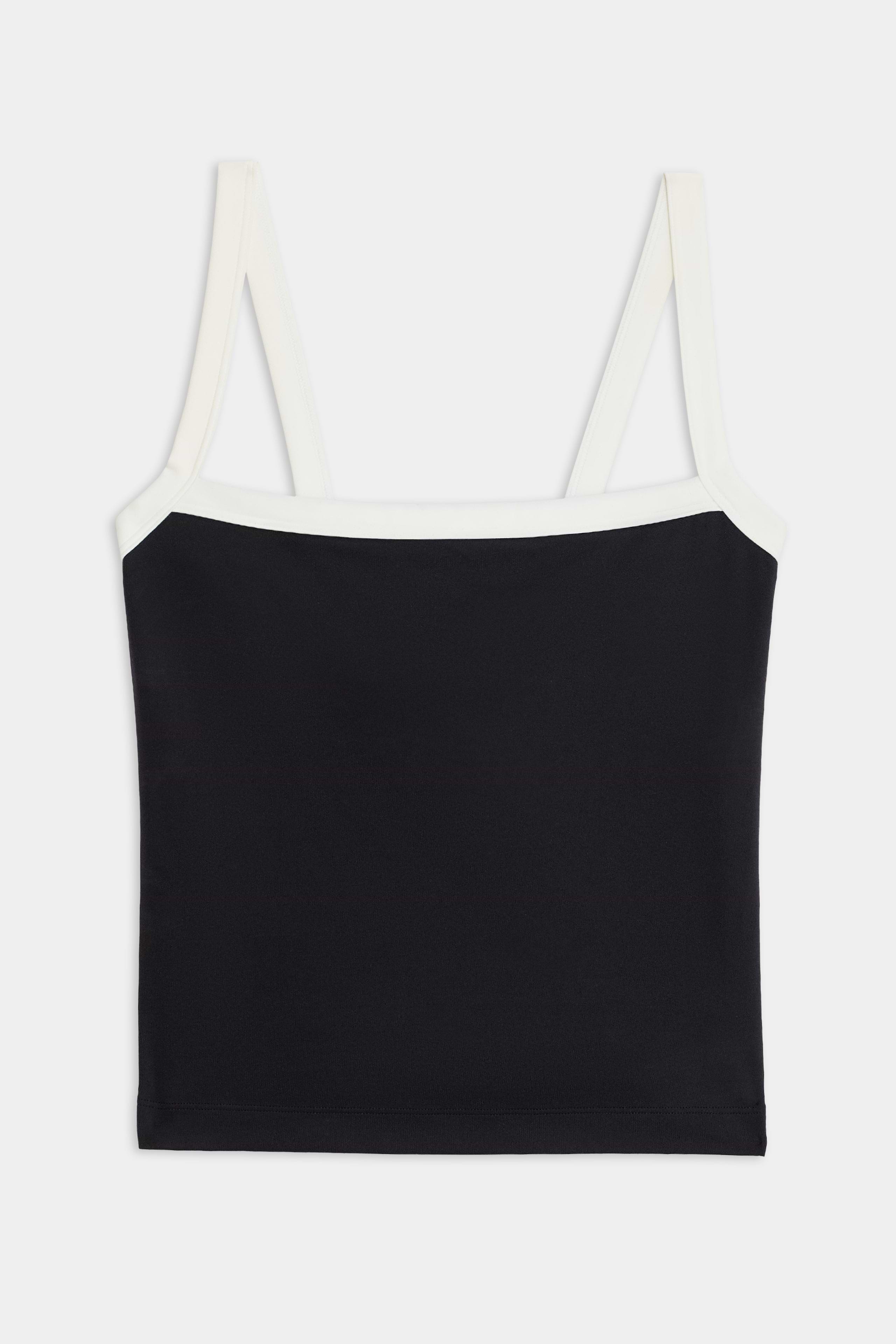 The Monah Rigor Tank by SPLITS59 is designed for gym workouts, showcasing a black camisole style with white straps and trim, elegantly presented on a plain white background.