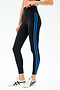 A person wears SPLITS59 Ella High Waist Airweight 7/8 leggings in Black/Classic Blue, featuring two blue side stripes, paired with white sneakers against a plain white background.